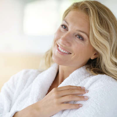 Portrait of beautiful 40-year-old woman relaxing in bathrobe at home